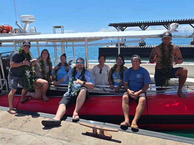 Group of visitors posing together on the boat before their ocean tour Group of visitors posing together on the boat before their ocean tour